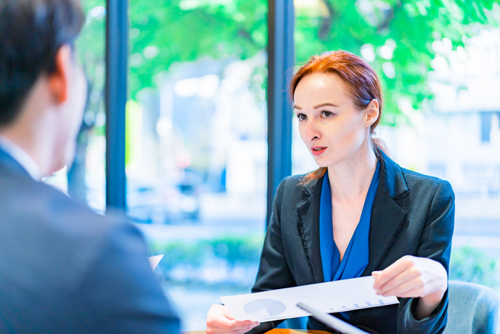 A financial advisor reviewing an annual 401(k) fee disclosure notice with a client.